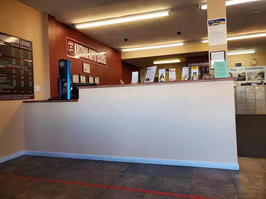 The Arizona Auto License front counter in Tucson, with the posted fee board on the wall behind it.